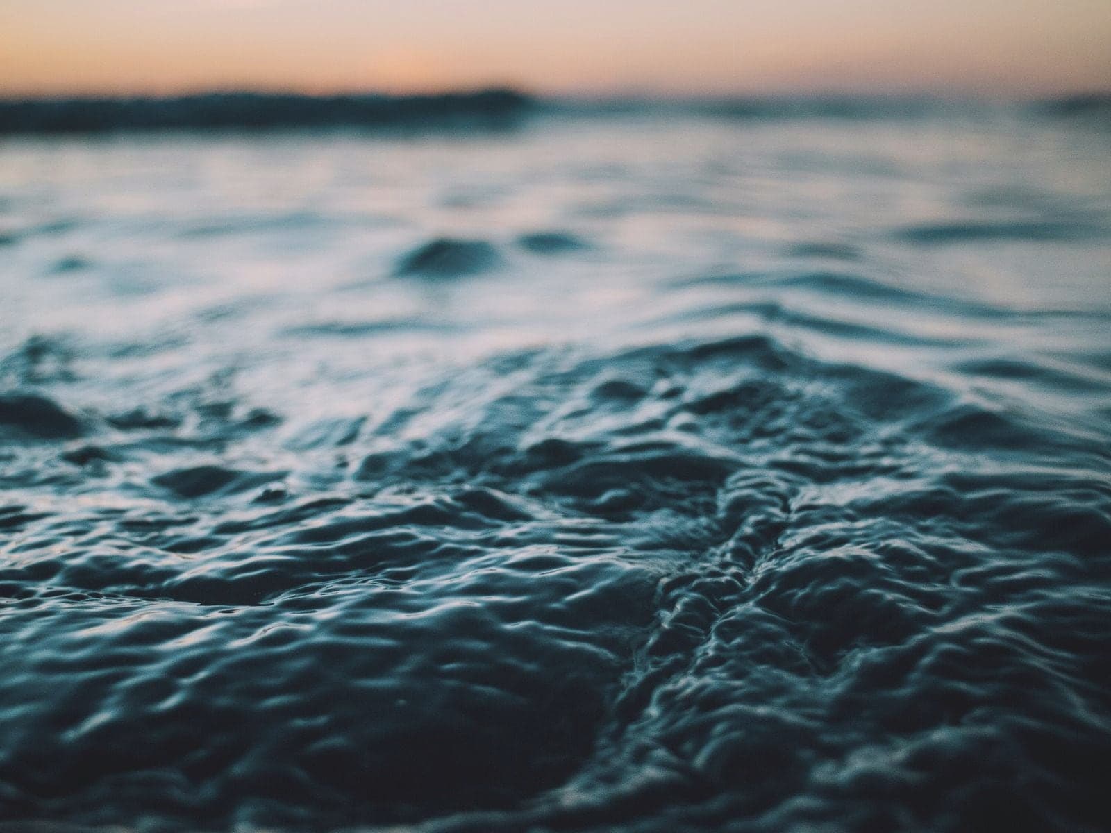 Rippling teal ocean water at dusk.